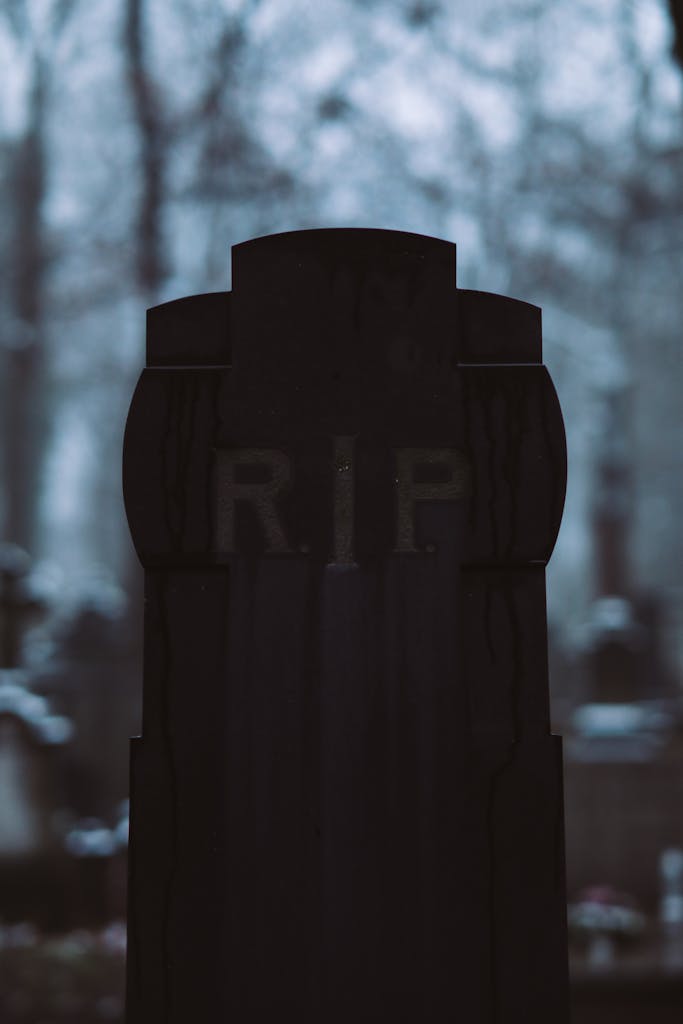 A close-up of a gravestone with RIP inscription in a quiet cemetery setting.